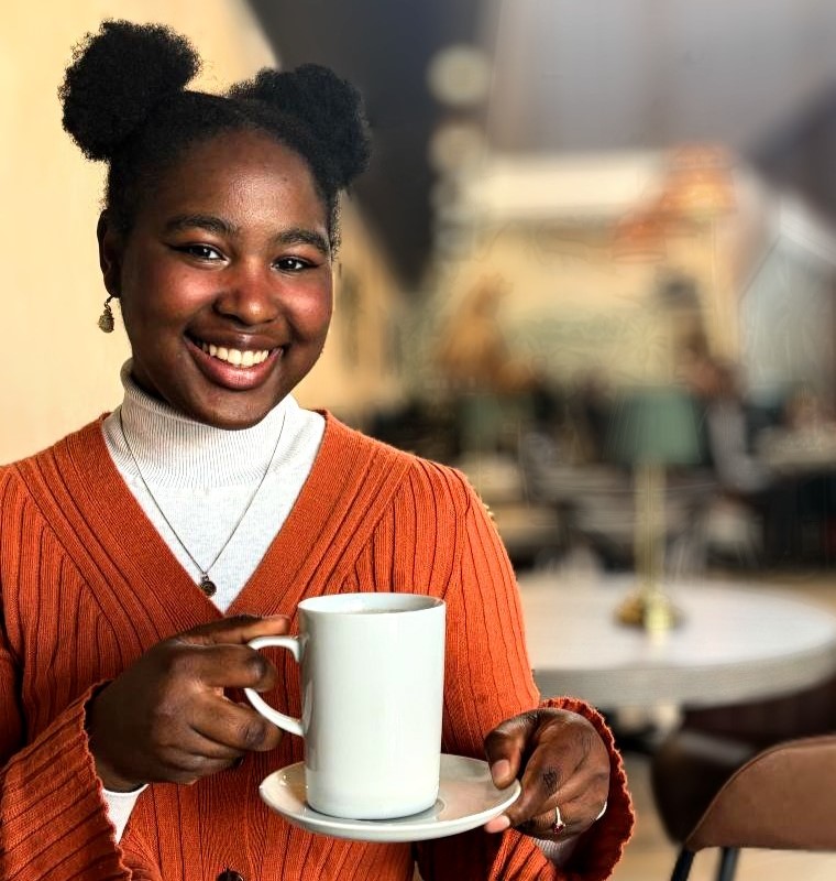 A photograph of Prudence Nabila holding a coffee cup